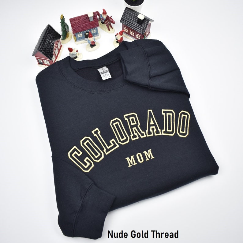 Custom embroidered sweatshirt with athletic font. Colorado Mom embroidered crewnecks with custom font embroidery. Black sweatshirt with nude gold embroidery. Perfect personalized gifts for dad, mom, grandpa, grandma, couples and loved ones.