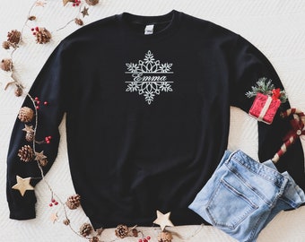 May include: Black sweatshirt with a white snowflake design and the name "Emma" written across the middle.