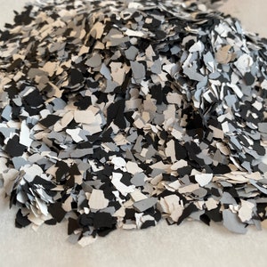 May include: A pile of black, white and grey epoxy flakes for use in resin art or epoxy flooring projects.