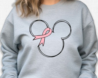 Könnte beinhalten: Ein graues Sweatshirt mit einer schwarzen Umrandung von Mickey Mouse Ohren und einem rosa Band in der Mitte. Das Band ist ein Symbol für die Sensibilisierung für Brustkrebs.