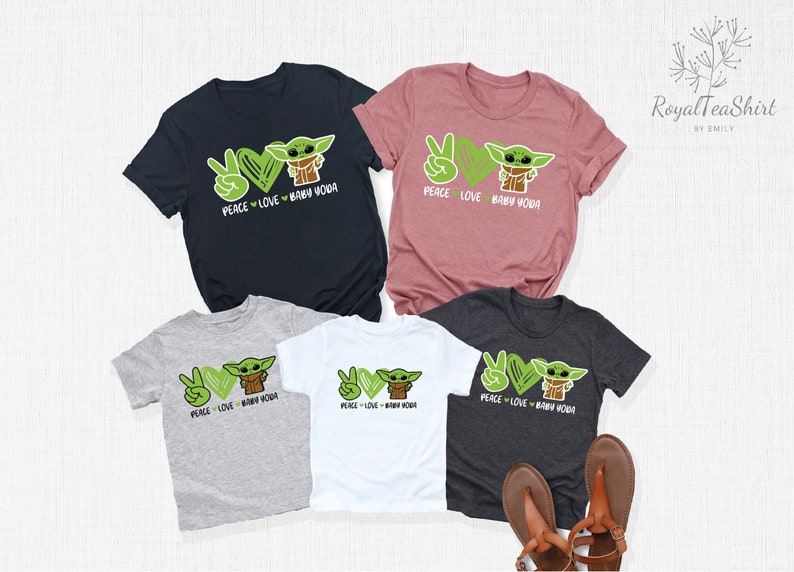 Puede incluir: Cuatro camisetas con un signo de paz, un coraz&oacute;n y un gr&aacute;fico de Baby Yoda. Las camisetas son de diferentes colores: negro, gris, blanco y rosa. El texto en las camisetas dice "Peace Love Baby Yoda".