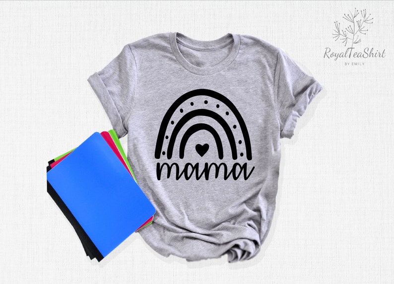 May include: A grey t-shirt with a black rainbow design and the word "mama" underneath. The rainbow has a small heart in the centre.