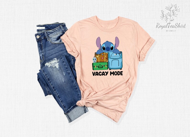 May include: A pink t-shirt with a blue cartoon character holding luggage and the text "Vacay Mode".