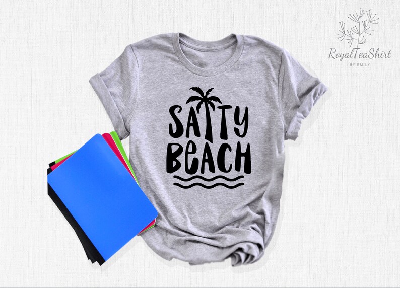 May include: A gray t-shirt with a black graphic that says "SAPPY BEACH" with a palm tree and waves.