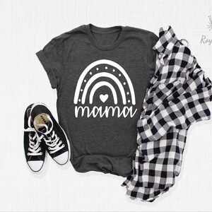 May include: A dark grey t-shirt with a white rainbow and the word "mama" printed on the front. The rainbow has a small white heart in the centre.