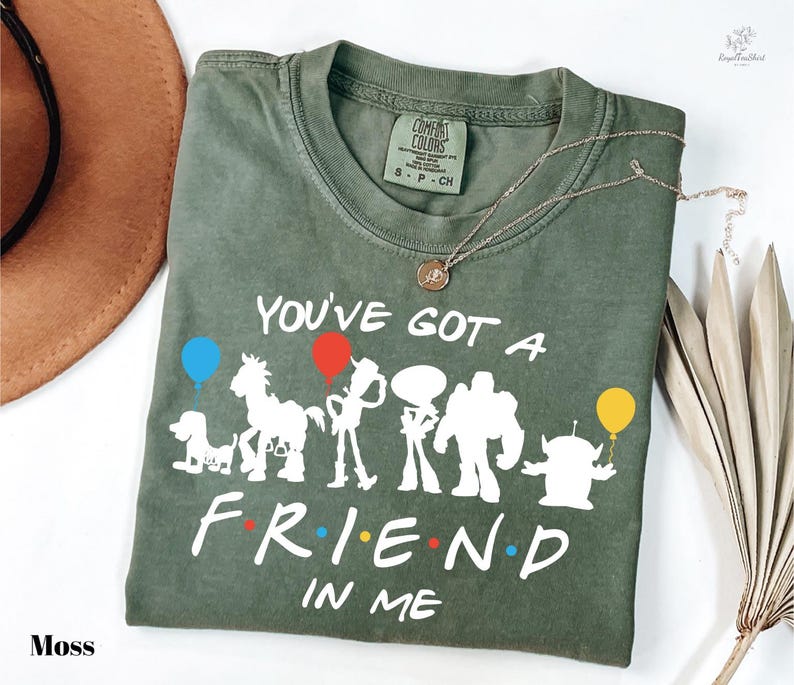 A green t-shirt with a printed design of characters from the TV show "Friends" and the text "You've got a friend in me" printed on it.