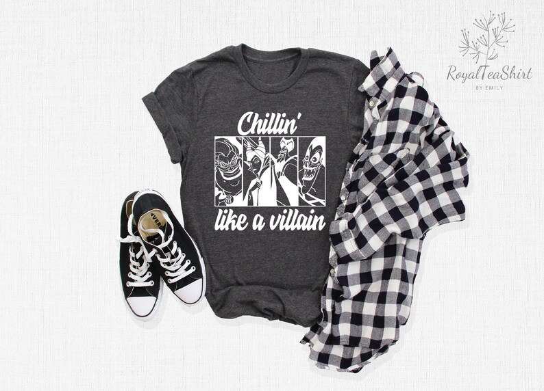 K&ouml;nnte beinhalten: Ein dunkelgraues T-Shirt mit einer wei&szlig;en Grafik von Disney-Schurken. Der Text auf dem Shirt lautet "Chillin' like a villain".