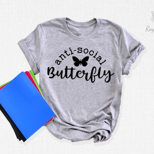 May include: Gray t-shirt with the text "anti-social butterfly" in black lettering with a black butterfly graphic.