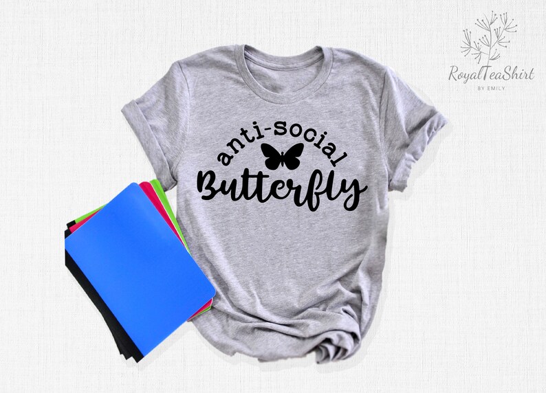 May include: Gray t-shirt with the text "anti-social butterfly" in black lettering with a black butterfly graphic.