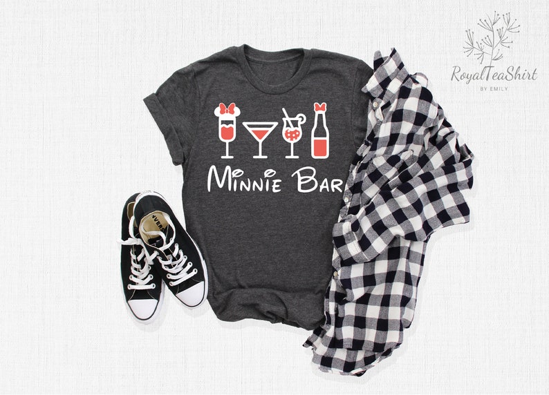 May include: A dark gray t-shirt with a white graphic of a Minnie Mouse head with a red bow and four red drink icons. The text "Minnie Bar" is written in white below the icons.