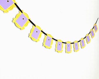 May include: A yellow and purple garland with a string of connected picture frames. Each frame has a purple center and a yellow border.