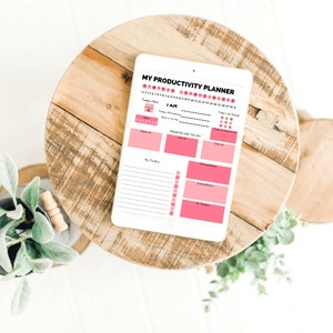 Op de afbeelding: Een digitale productiviteits planner op een tablet met een roze en wit ontwerp. De planner bevat secties voor dagelijkse doelen, takenlijsten en een stemmingstracker.