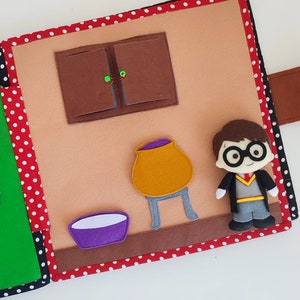 May include: A felt book page with a brown cabinet, a purple bowl, a yellow cauldron on a gray stand, and a character from the Harry Potter series wearing a black robe and glasses.