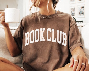 May include: A brown t-shirt with the text "BOOK CLUB" in white letters. The t-shirt is shown in the colour "Espresso".