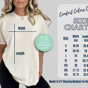 Pu&ograve; includere: Tabella delle taglie per una t-shirt con misure in pollici. La tabella mostra la larghezza e la lunghezza della t-shirt nelle taglie dalla S alla 4XL. Il testo "Size Up 1-2 Sizes for an Oversized Look!" &egrave; in un cerchio verde.