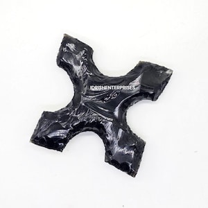 Puede incluir: Una punta de flecha de obsidiana negra con forma de estrella de cuatro puntas. La punta de flecha es lisa y pulida, con un acabado brillante. IDRISHEnterprises está impreso en la punta de flecha.