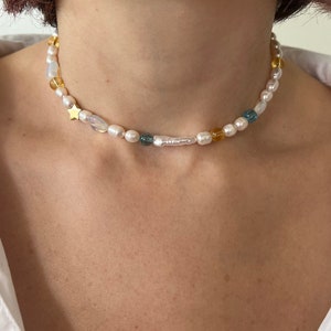 mismatched pearl and bead necklace with blue and yellow beads, star charm and stick biwa pearl, necklace choker on the model