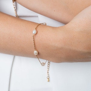 dainty pearl bracelet on a model. gold pearl bracelet with extension