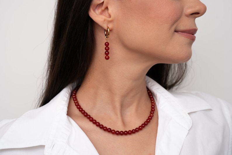 Handmade red carnelian gemstone necklace featuring deep red natural stone beads with a secure carabiner clasp. This elegant crystal choker is perfect for layering, offering a boho yet minimalist style. Ideal as a healing crystal necklace, August birthstone gift, or a unique present for her.