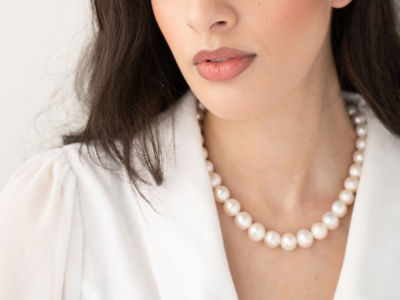 large pearl necklace on the model made with cultured freshwater 12mm round white pearls, includes stainless steel toggle clasp