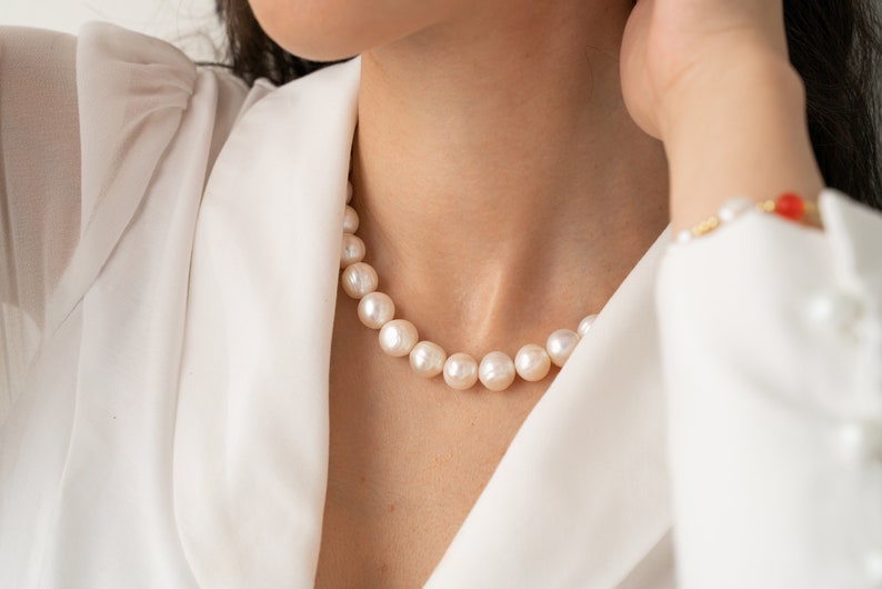 large pearl necklace on the model made with cultured freshwater 12mm round white pearls, includes stainless steel toggle clasp