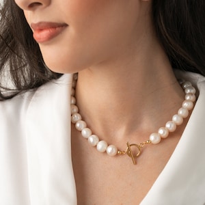 large pearl necklace on the model made with cultured freshwater 12mm round white pearls, includes stainless steel toggle clasp