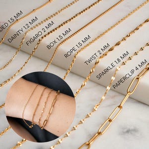 May include: A close-up of eight gold chains of different styles and sizes, laid out on a white surface. The chains are labelled with their names and sizes in millimetres.  The chains are beaded, dainty, figaro, box, rope, twist, sparkle, and paperclip.