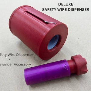 Può includere: Un erogatore di filo di sicurezza in plastica rossa con un accessorio avvolgitore del nucleo in plastica viola. L'erogatore ha una fessura per tagliare il filo e un foro per alimentare il filo. L'accessorio ha un'estremità a forma di stella.