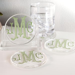 May include: Set of four clear acrylic coasters with a green monogram "JMC" on each. The coasters are in a clear acrylic holder.