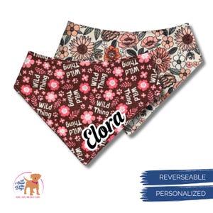 May include: Two reversible dog bandanas. One is brown with pink flowers and the text "Wild Thing" and "Elora". The other is cream with floral patterns. The bandanas are personalized.