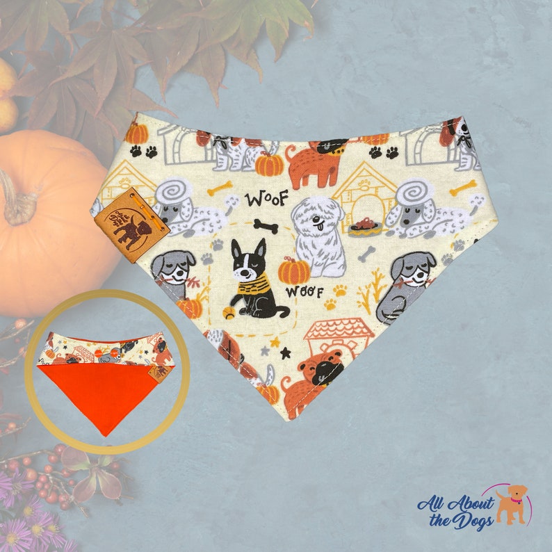 Pu&ograve; includere: Bandana per cani con sfondo crema con cani dei cartoni animati, zucche e la parola "Woof". La bandana ha un design reversibile con interno arancione. &Egrave; attaccata una piccola etichetta in pelle. Prodotto da "All About the Dogs".