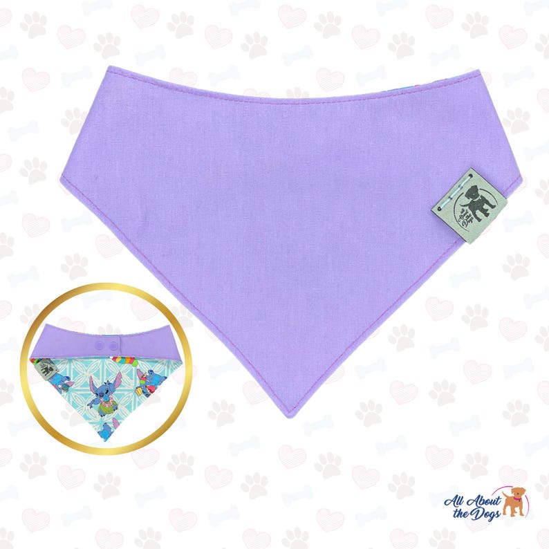 Puede incluir: Un pa&ntilde;uelo para perros de color lavanda con una secci&oacute;n estampada con personajes de dibujos animados. El pa&ntilde;uelo tiene una etiqueta con un logotipo. El dise&ntilde;o es adecuado para mascotas.
