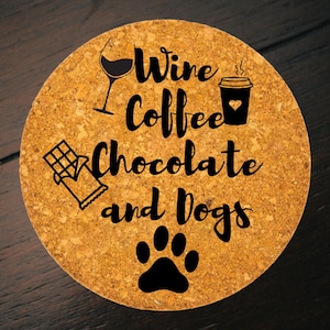 May include: Round cork coaster with the words "Wine Coffee Chocolate and Dogs" in black script. The coaster features illustrations of a wine glass, coffee cup, chocolate bar, and a dog paw print.