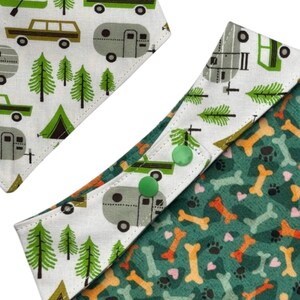 Op de afbeelding: Twee hondenbandana's met kampeer- en hondenbotpatronen. E&eacute;n bandana heeft een witte achtergrond met groene bomen, een groene tent en bruine auto's en campers. De andere bandana heeft een groene achtergrond met oranje en gele hondenbotten en pootafdrukken.