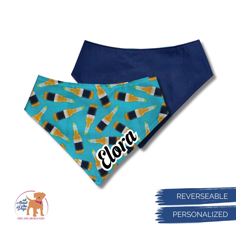 May include: Reversible dog bandana with a blue and yellow beer bottle pattern on a turquoise background. The reverse side is solid navy blue. The name "Elora" is printed on the bandana. The bandana is personalized.
