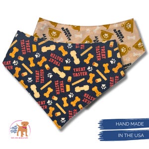 May include: Two dog bandanas. One is navy blue with bone, treat, and paw print patterns, and the text "TREAT TASTER". The other is tan with bone and bowl patterns, and the text "BONE APPETIT". The bandanas are handmade in the USA.