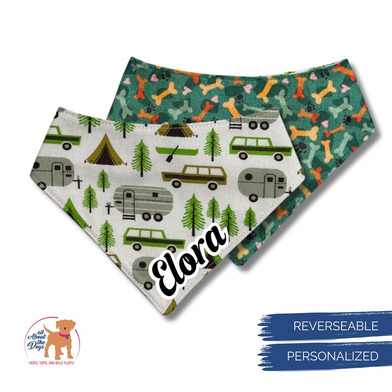 Op de afbeelding: Omkeerbare bandana voor honden met een campingthema. De ene kant heeft een witte achtergrond met groene bomen, campers en tenten. De andere kant heeft een groene achtergrond met oranje en bruine hondenbotten. De naam "Elora" is gedrukt.