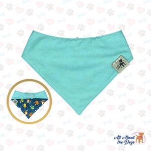 May include: A turquoise blue dog bandana with a snap closure. The bandana has a small logo on the bottom right corner that says "All About the Dogs".