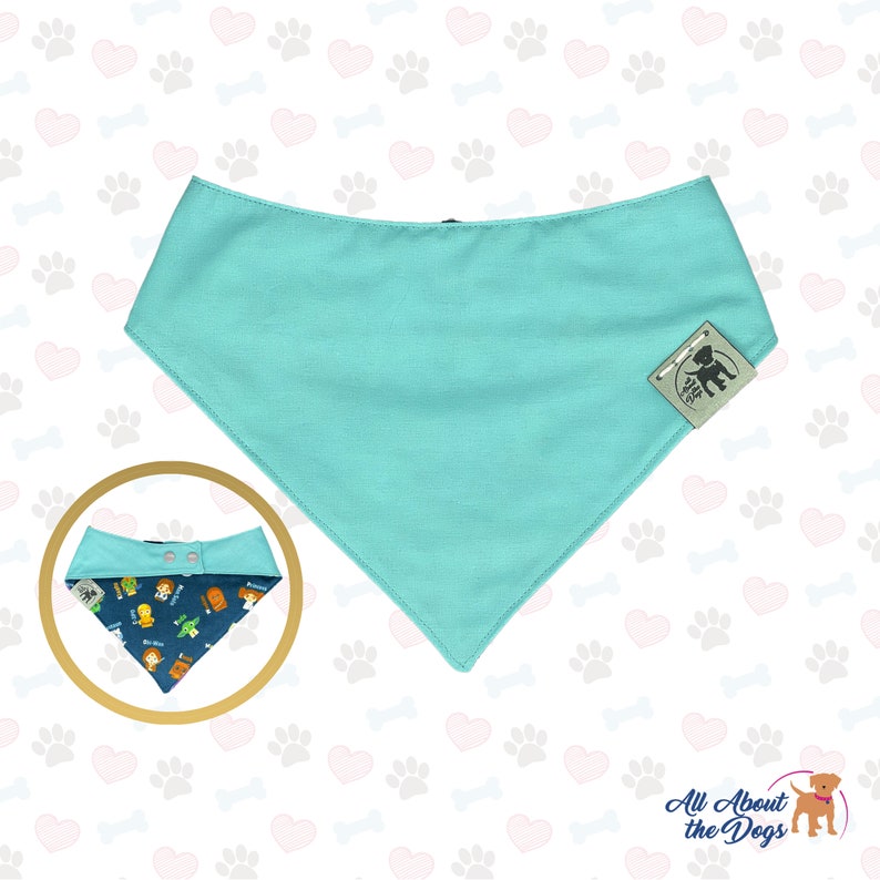 May include: A turquoise blue dog bandana with a snap closure. The bandana has a small logo on the bottom right corner that says "All About the Dogs".