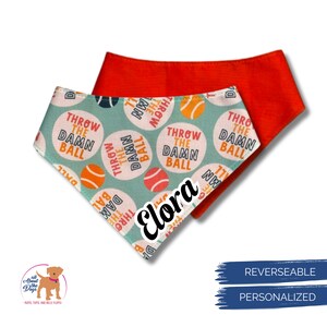 Peut inclure: Bandana r&eacute;versible pour chien avec un motif bleu sarcelle et blanc avec le texte "THROW THE DAMN BALL" et des balles de tennis orange et rouges. Le verso est orange uni. Le nom "Elora" est imprim&eacute;.