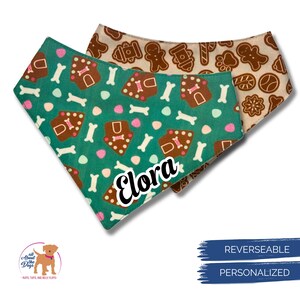 K&ouml;nnte beinhalten: Wende-Hunde-Bandana mit einem tealfarbenen Lebkuchenhaus- und Knochenmuster, personalisiert mit dem Namen "Elora". Die R&uuml;ckseite zeigt ein hellbraunes Lebkuchen-Design. Enth&auml;lt die Texte "REVERSEABLE" und "PERSONALIZED".