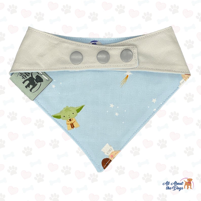 Peut inclure: Un bandana pour chien bleu clair avec une bordure blanche et trois boutons pression. Le bandana pr&eacute;sente un imprim&eacute; sur le th&egrave;me de l'espace avec des &eacute;toiles, des plan&egrave;tes et des personnages de Star Wars. Le bandana est fabriqu&eacute; par All About the Dogs.
