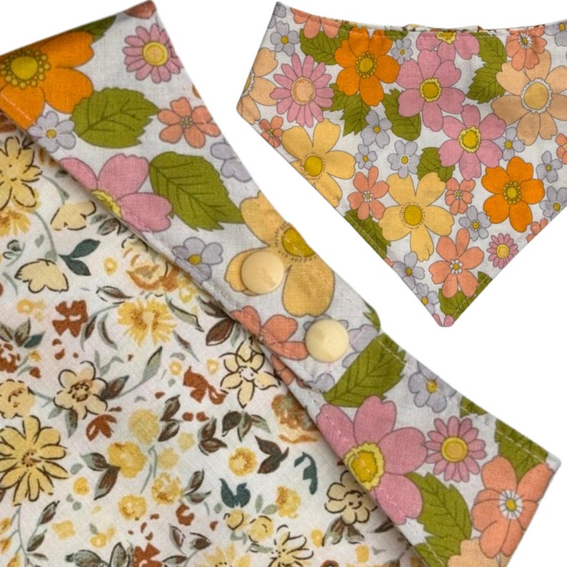 Pode incluir: Conjunto de babete e bandana para beb&eacute; com padr&atilde;o floral em tons de laranja, rosa, amarelo e verde sobre fundo branco. O babete tem dois bot&otilde;es de press&atilde;o creme. O tecido tem uma est&eacute;tica vintage e retro.