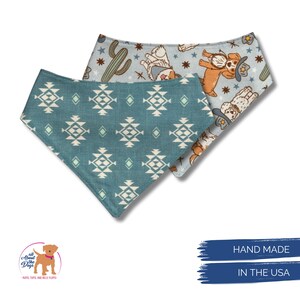 May include: Two dog bandanas. One is teal with a white geometric pattern. The other is light blue with a pattern of dogs wearing cowboy hats, cacti, and stars. The bandanas are handmade in the USA.