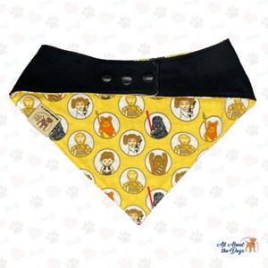 May include: Yellow dog bandana with a black adjustable collar. The bandana features a repeating pattern of Star Wars characters in circles. The characters include Darth Vader, Chewbacca, Princess Leia, R2-D2, C-3PO, and Yoda.