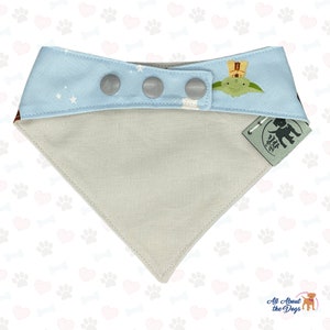 Peut inclure: Un bandana pour chien bleu clair avec un motif d'&eacute;toiles blanches et un graphique de Yoda et un personnage de Star Wars. Le bandana a trois fermetures &agrave; pression et un dessous beige. Le bandana a une petite &eacute;tiquette avec le texte "All About the Dogs" dessus.
