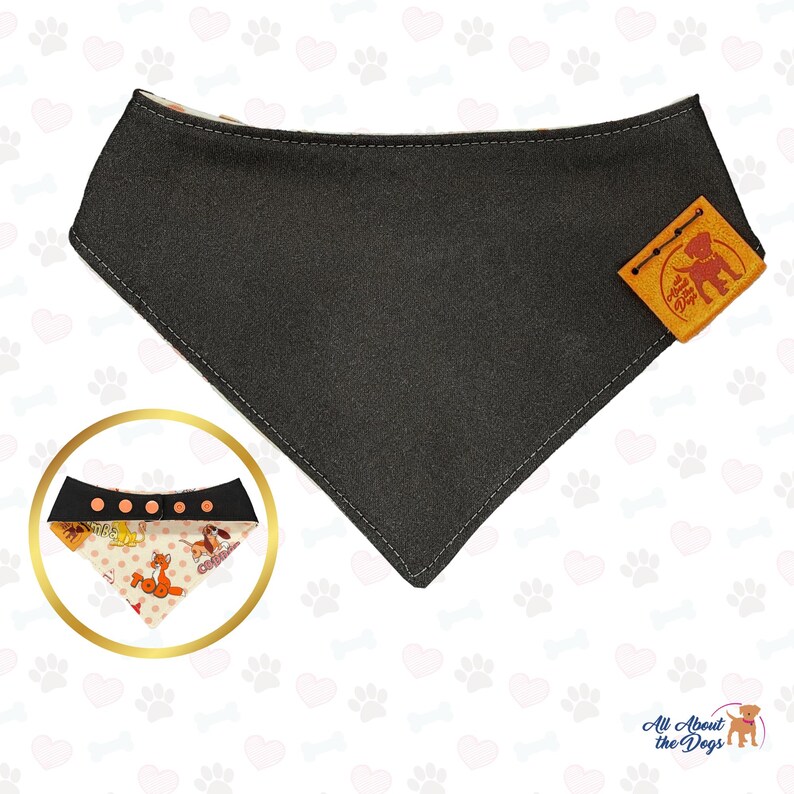 May include: A black and white dog bandana with a brown leather tag that says "All About the Dogs". The bandana has a white background with brown polka dots and a pattern of dogs in various poses.