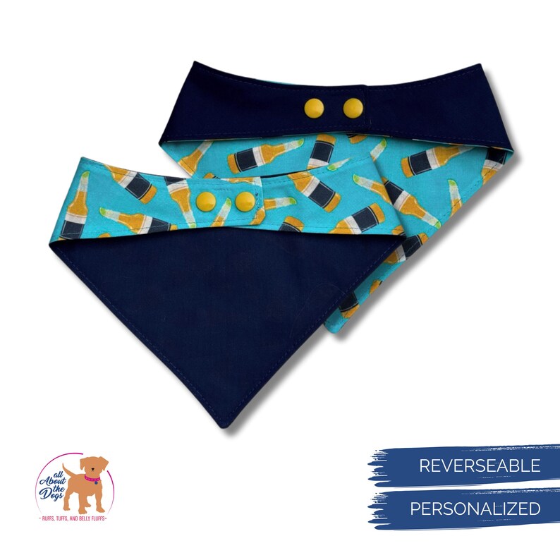 May include: Reversible dog bandana with a navy blue exterior and a turquoise interior patterned with beer bottles. The bandana has yellow snap closures and is personalized.