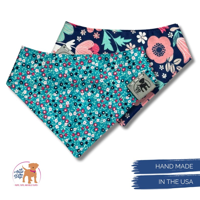 K&ouml;nnte beinhalten: Zwei Hunde-Bandanas mit floralen Mustern. Eines ist t&uuml;rkis mit kleinen wei&szlig;en, roten und schwarzen Blumen. Das andere ist marineblau mit rosa und wei&szlig;en Blumen. Beide haben ein Etikett mit der Aufschrift "All About Dogs" und "Hand Made In The USA."