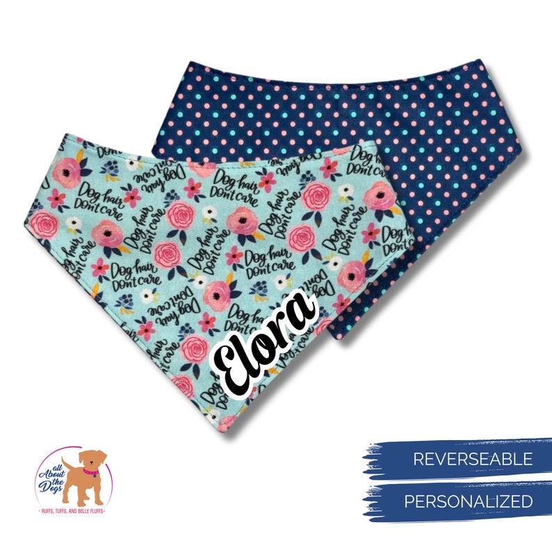 May include: Two reversible dog bandanas. One is light blue with pink flowers and the text "Dog hair, don't care." The other is navy blue with pink polka dots. The name "Elora" is printed on the light blue bandana.